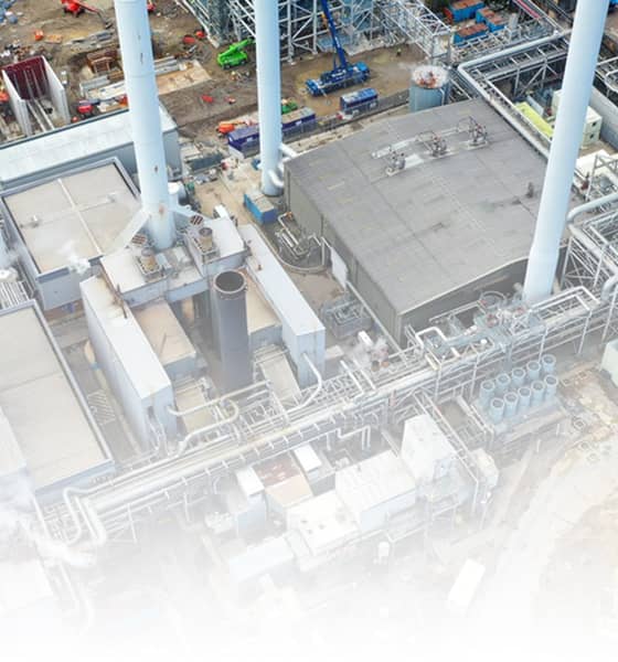 Luchtfoto van een industriële productielocatie met pijpleidingen, opslagtanks, gebouwen.