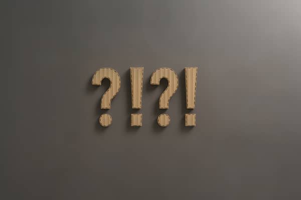 grå baggrund med spørgsmålstegn og udråbstegn i bølgepap