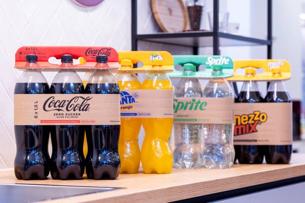 Flessen frisdrank, Coca-Cola, Fanta, Sprite, handvat van golfkarton in supermarktschap