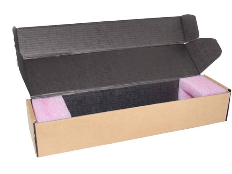 Geöffnete Verpackung aus Wellpappe mit schwarzem Innendruck und Polster innen.