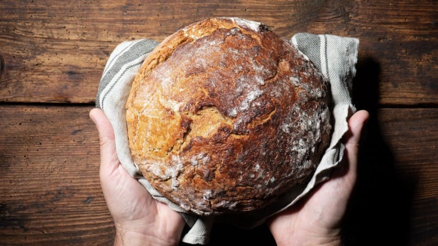 Zwei Hände halten ein Brot.