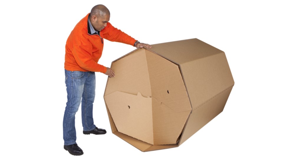 Mann baut Oktabiner aus Wellpappe zusammen und hantiert am Boden dafür. 