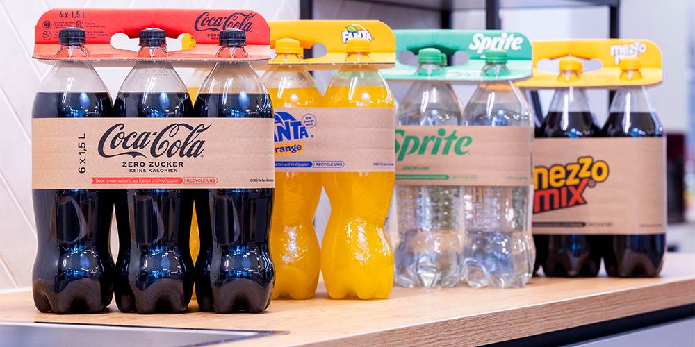 The image shows the innovative packaging solution of DS Smith  - Lift Up. There are four six-packs behind each other, including CocaCola, Fanta, Sprite and Mezzo Mix. Every package has a Lift Up.