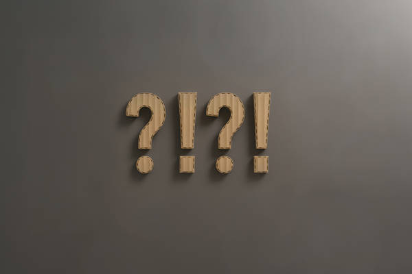 grå baggrund med spørgsmålstegn og udråbstegn i bølgepap