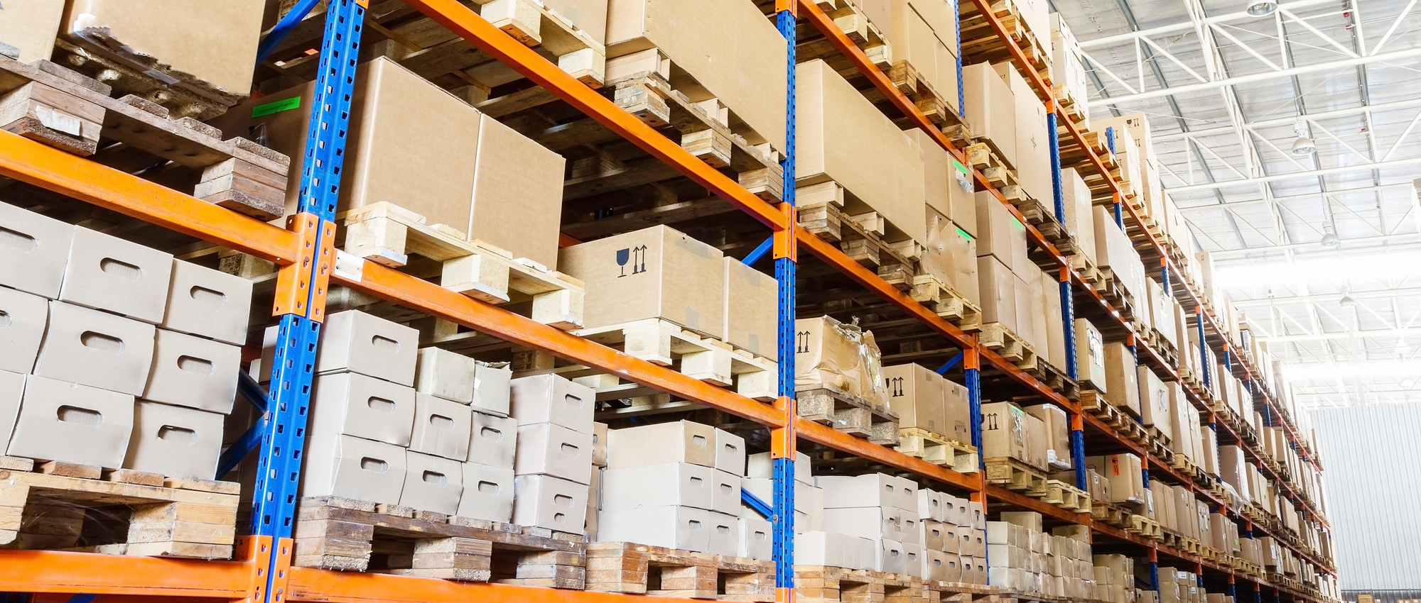 teollisuusvaraston hylly jossa pahvisia pakkauksia