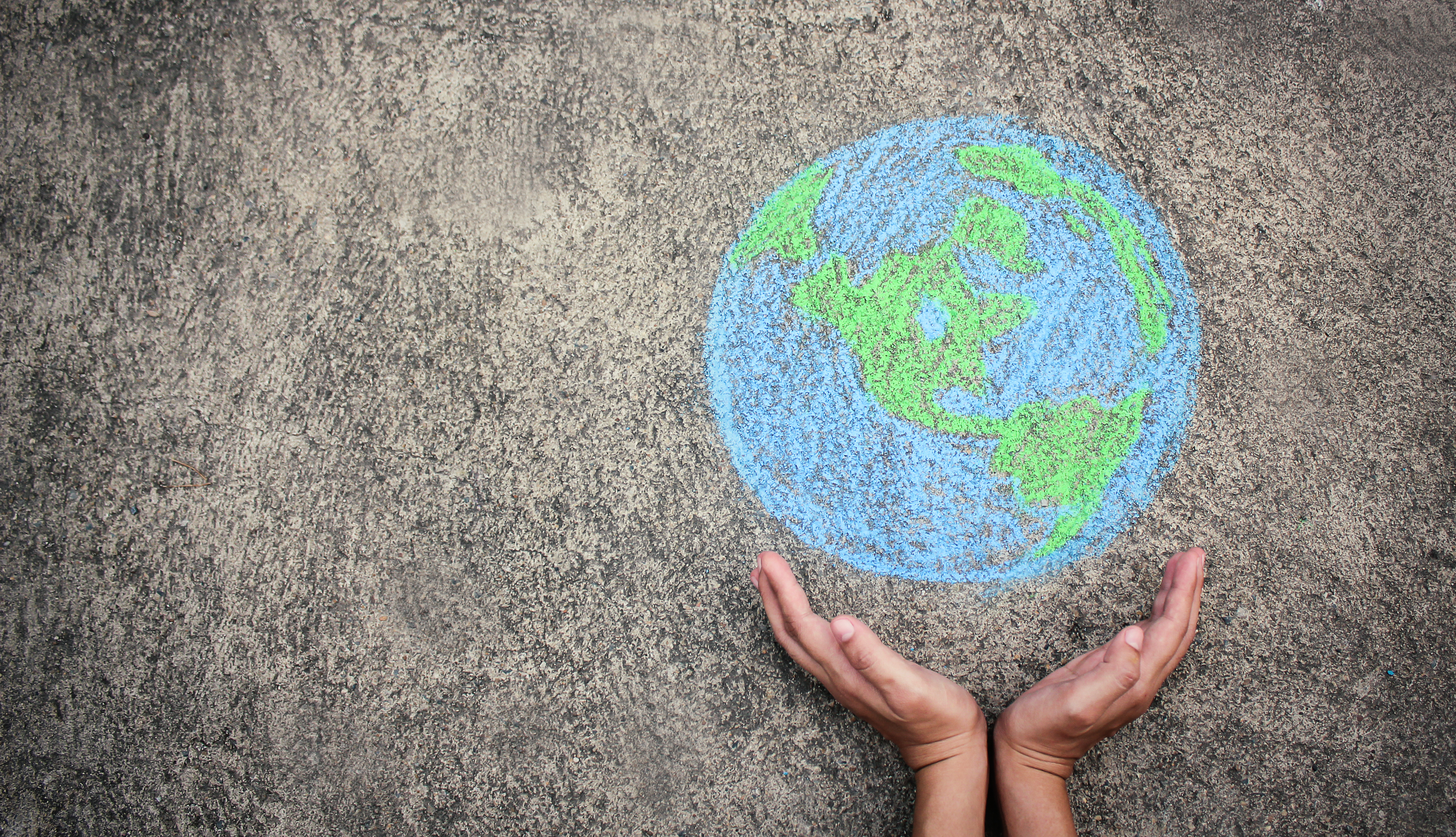 Hand around a drawing of the world
