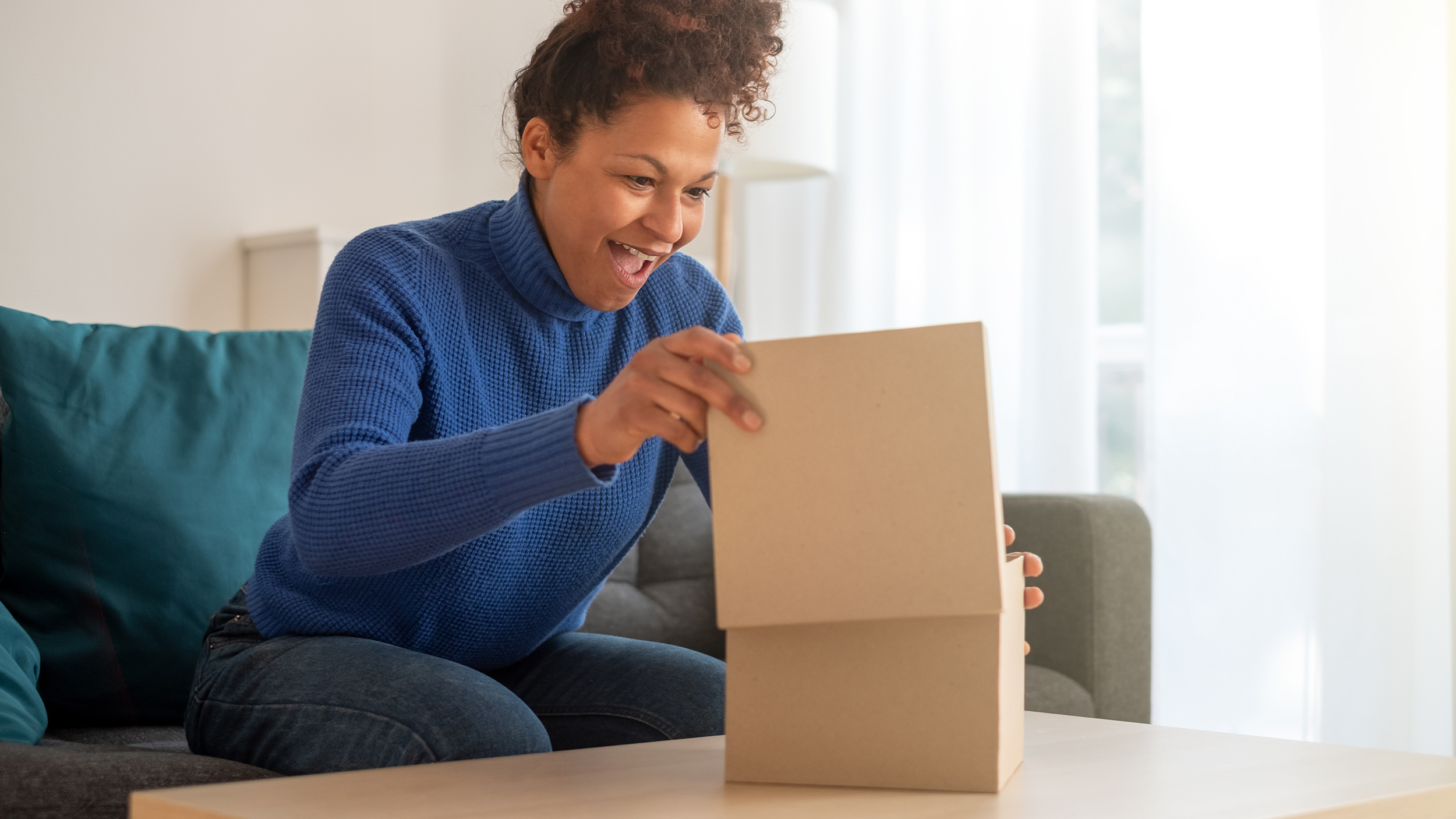 nainen katsoo aaltopahvista laatikkoa