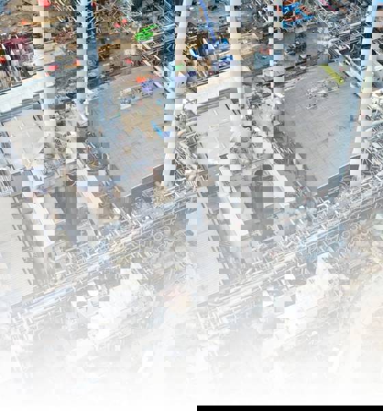 Luchtfoto van een industriële productielocatie met pijpleidingen, opslagtanks, gebouwen.