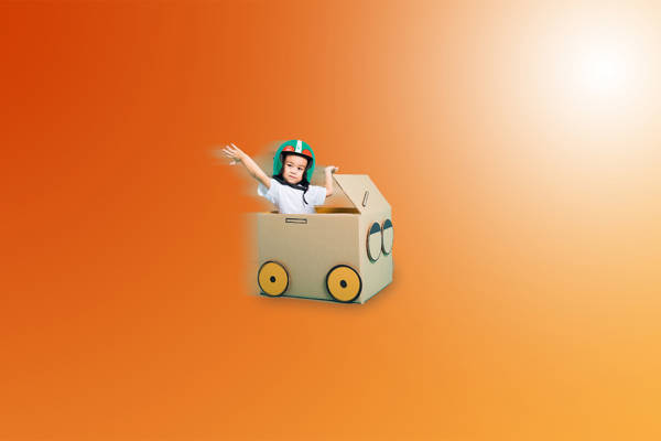 poika pahvilaatikossa leikkimässä