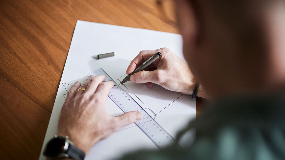 käsi ja suunnittelupaperi, johon käis piirtää