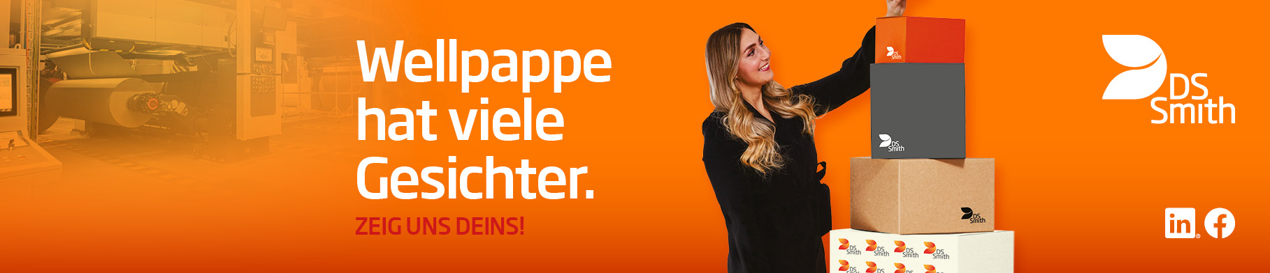 junge blonde Frau in dunklem Kleid steht links von einem Wellpappaufsteller und hält einen kleinen Wellpappkarton in der Hand und lächelt.