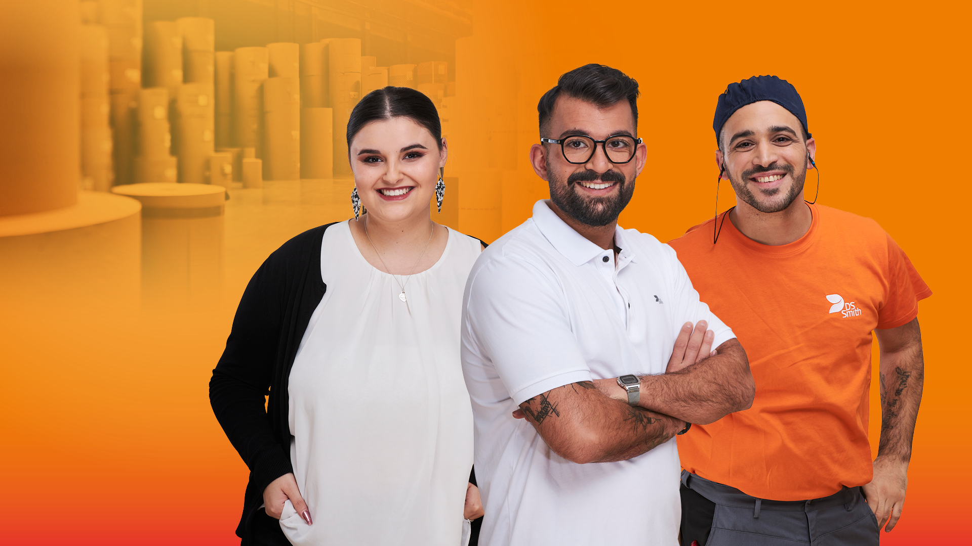 Eine Gruppe von 3 Mitarbeitenden vor orangenem Hintergrund. In der Mitte ein junger Mann mit weißem T-Shirt und vor der Brust verschränkten Armen. Es handelt sich um legere Bekleidung für das Büro (Design). Links von ihm eine junge dunkelhaarige Frau mit Zopf in weißer Bluse mit dunkler Strickjacke im Büro Look. Rechts von ihm ein dunkelhaariger junger Mann. Mütze und Gehörschutz und oranges T-Shirt, Arbeitskleidung. Links von der Gruppe steht der Employer Branding Claim „Wellpappe hat viele Gesichter. Zeig uns Deins.“