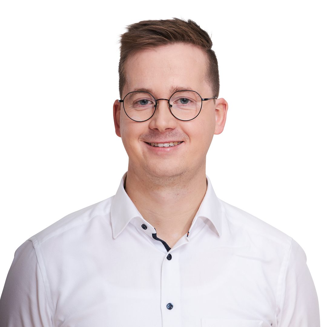 Portrait eines junger blonden Mannes mit Brille, mit weißem Hemd. Er lächelt in die Kamera.