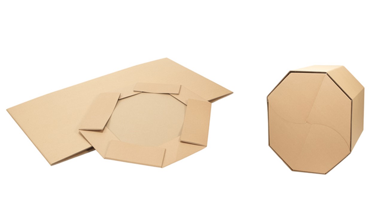 Zusammengefalteter Oktabiner aus Wellpappe liegt neben einem aufgebauten Exemplar.