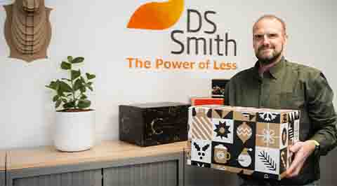 Medewerker DS Smith toont trots een geproduceerde kerstpakketdoos