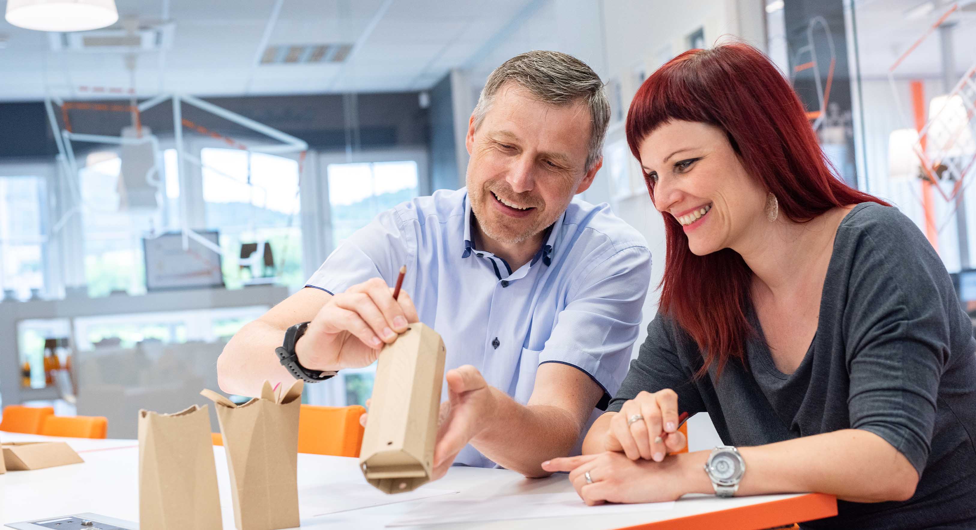 Verpakkingsontwerpers van DS Smith werken samen aan een duurzaam kartonnen verpakkingsprototype in een designstudio.