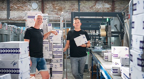 Twee collega's van winparts in e-commerce magazijn met verpakkingen 