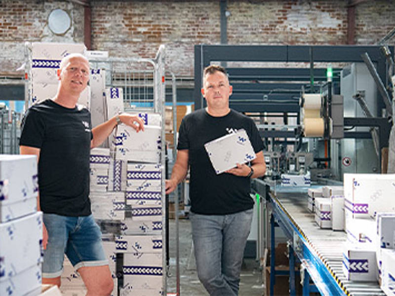 Twee collega's van winparts in e-commerce magazijn met verpakkingen