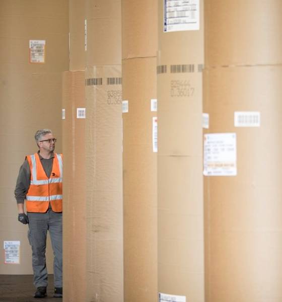 A person standing amongst giant paper reels