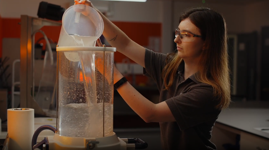 DS Smith lab technician pouring water into a beaker to test packaging quality